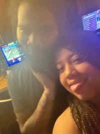 a man and woman posing for a photo in front of a computer
